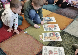 Chłopiec układa z cyfr numer alarmowy.