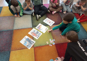 Chłopiec układa z cyfr numer alarmowy.