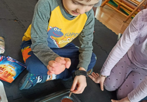 chłopiec dodaje czekoladę do babeczek