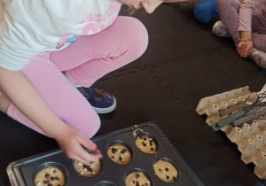 dziewczynka dodaje czekoladę do babeczek