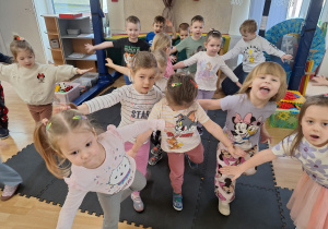 dzieci stoją na jednej nodze