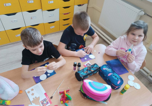 Dzieci wykonują prace plastyczną.