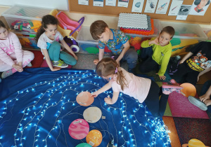 Dzieci biorą udział w zajęciach o tematyce "Układ Słoneczny".