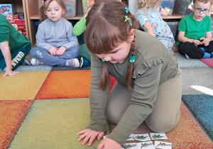 Dziewczynka przelicza dinozaury.