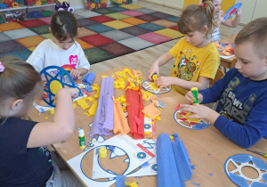 Dzieci wykonują kolorowe witraże.