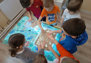 Dzieci uczestniczą w zabawach sensorycznych.