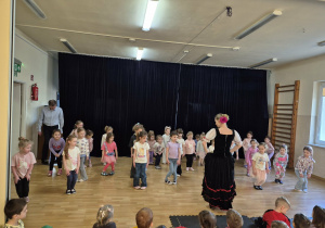 Tancerka prezentuje grupie dzieci kroki taneczne