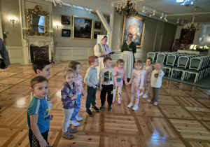Dzieci stoją w wielkiej sali muzeum