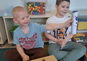 Dzieci biorą udział w zabawie sensorycznej "Damskie pudełko".