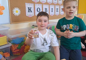 Dzieci biorą udział w zabawie sensorycznej "Damskie pudełko".