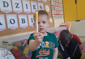 Dzieci biorą udział w zabawie sensorycznej "Damskie pudełko".