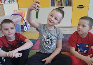 Dzieci biorą udział w zabawie sensorycznej "Damskie pudełko".