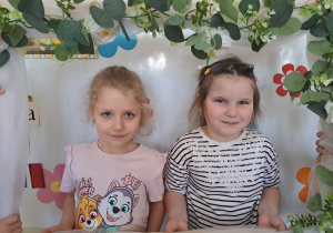 Zdjęcie dziewczynek w kwiatowej ramce.