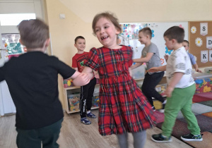 Dzieci biorą udział w zabawie "Taniec z kwiatkiem"