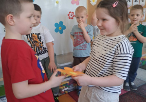 Dzieci biorą udział w zabawie "Taniec z kwiatkiem"