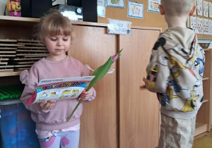 Chłopiec wręcz dziewczynce kwiatka.