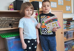 Chłopiec wręcz dziewczynce kwiatka.