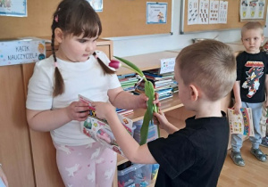 Chłopiec wręcz dziewczynce kwiatka.