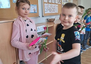 Chłopiec wręcz dziewczynce kwiatka.