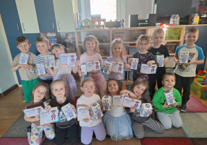 dzieci pozują do zdjęcia z prezentami