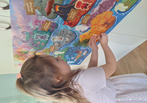 dziewczynka przykleja Brawojkę na plakat