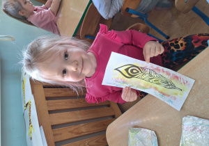 dziewczynka pokazuje pomalowane pióro