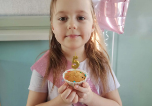 dziewczynka pozuje z babeczką