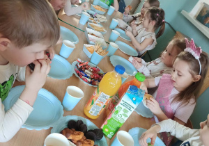 dzieci jedzą słodki poczęstunek