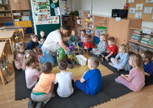 Nauczycielka prezentuje jak należy sadzić kwiaty i siać nasiona.