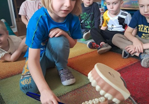 Chłopiec prezentuje jak myć zęby.