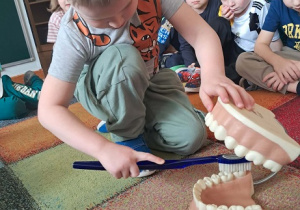 Chłopiec prezentuje jak myć zęby.