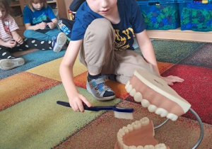 Chłopiec prezentuje jak myć zęby.