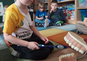 Chłopiec prezentuje jak myć zęby.