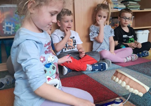 Dziewczynka prezentuje jak myć zęby.