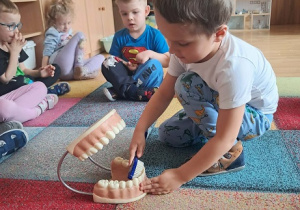 Chłopiec prezentuje jak myć zęby.