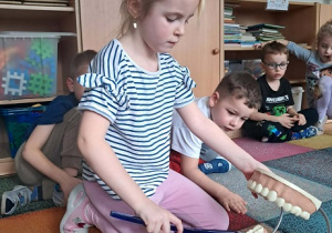 Dziewczynka prezentuje jak myć zęby.