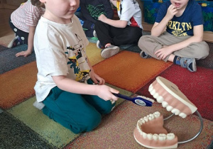 Chłopiec prezentuje jak myć zęby.