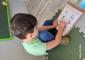 Dominik zaznacza na obrazku dzieci wesołe.