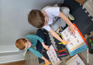 Remek i Filip zaznaczają na obrazku dzieci wesołe.