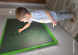 Remek rysuje na tablicy jak się dzisiaj czuje.