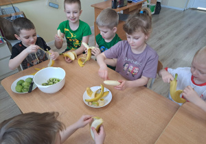 Dzieci przygotowują owoce do wykonania zdrowego koktajlu.