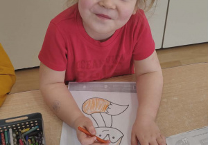 Dziewczynka koloruje sylwetę lisicy.