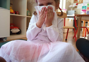 Dziewczynka pokazuje prawidłowe wydmuchiwanie nosa.