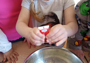 Dziewczynka dodaje barwnik do slime-gluta.