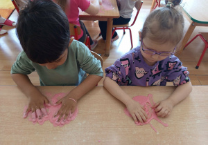 Dzieci bawią się slime-glutem.