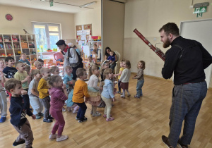 Muzyk gra na fagocie, dzieci poruszają się w rytmie muzyki