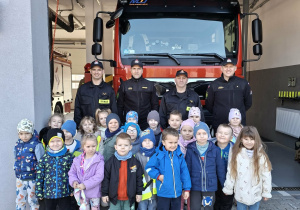 Dzieci pozują na tle wozu strażackiego