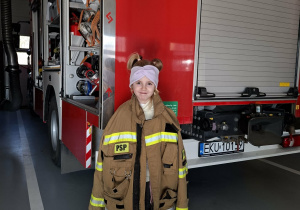 dziewczynka przymierza strój strażaka