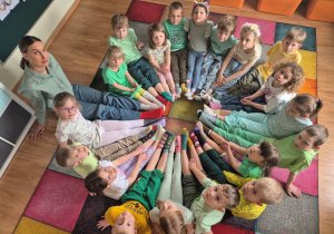 Dzieci wraz z panią Olgą prezentują kolorowe skarpetki - solidarność z osobami z zespołem Downa