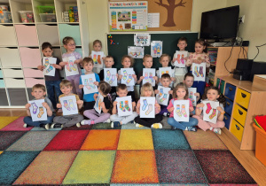 Dzieci prezentują zaprojektowanie przez siebie kolorowe skarpetki.